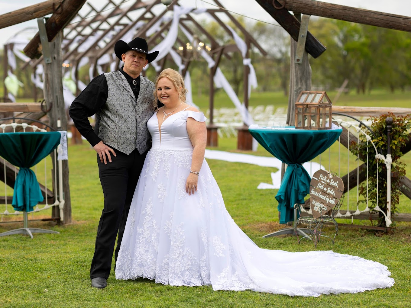 bride and groom under large pergola